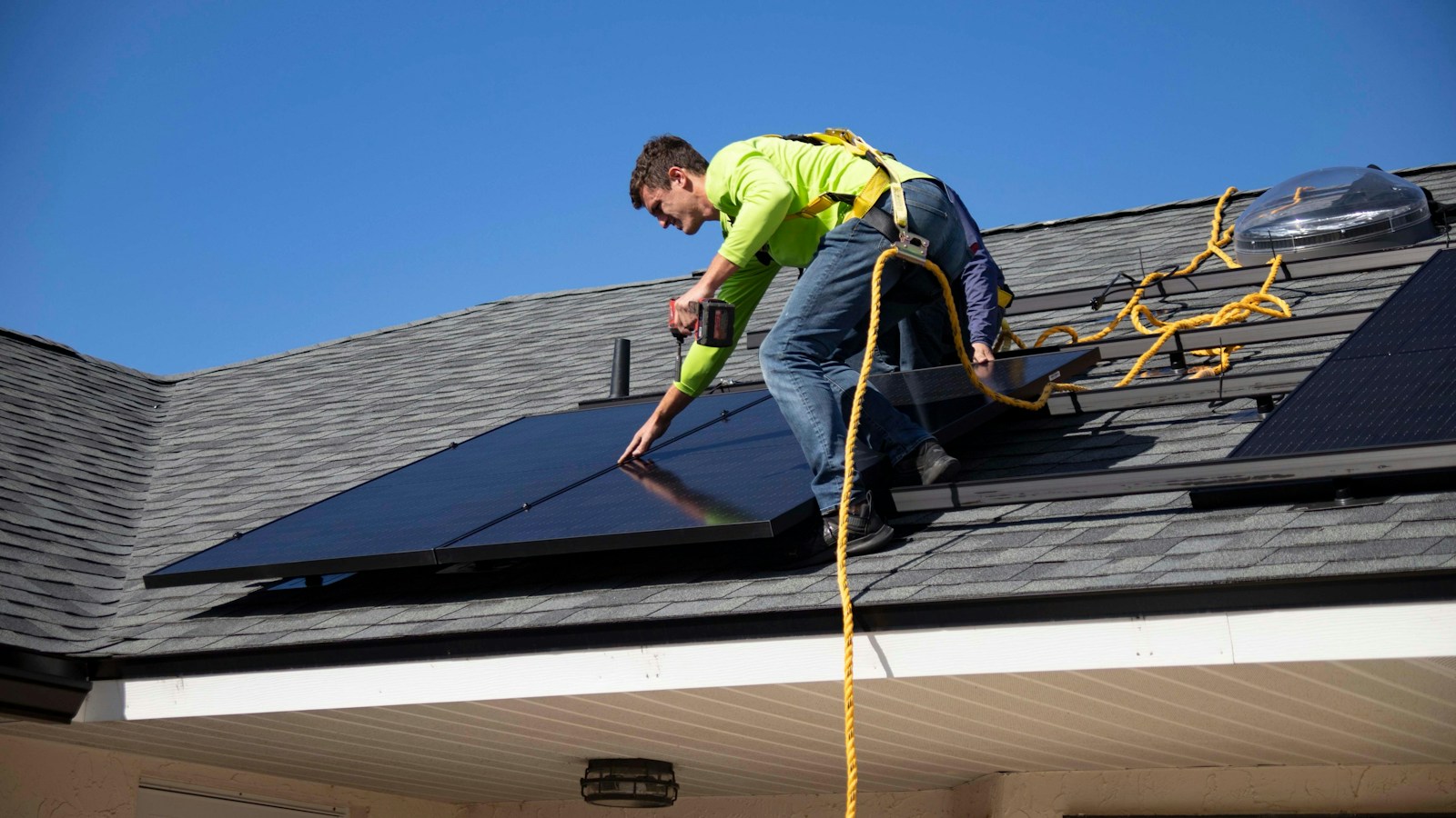 A technician fitting rooftop solar panels